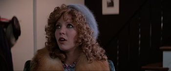 Movie still from “Blow Out” (1981), directed by Brian De Palma – A person with curly hair wearing a hat; Close Up shot, Over the shoulder angle
