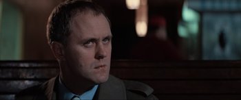 Movie still from “Blow Out” (1981), directed by Brian De Palma – A person wearing a suit and tie; Close Up shot, Low angle