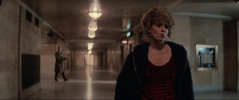 Movie still from “Blow Out” (1981), directed by Brian De Palma – A woman walking down a hallway in a building; Medium shot, Low angle