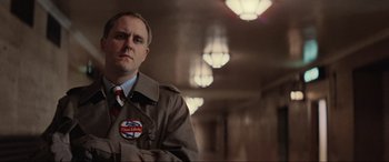 Movie still from “Blow Out” (1981), directed by Brian De Palma – A man in a brown jacket and a red and white tie; Medium shot, Low angle