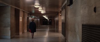 Movie still from “Blow Out” (1981), directed by Brian De Palma – A woman is walking down a hallway in a building; Extreme Wide shot, High angle