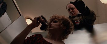 Movie still from “Blow Out” (1981), directed by Brian De Palma – A woman getting her hair brushed by a police officer; Close Up shot, Low angle