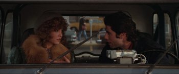Movie still from “Blow Out” (1981), directed by Brian De Palma – A man and a woman in a car looking at each other; Medium shot, Over the shoulder angle