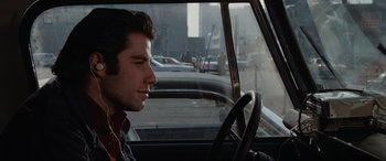 Movie still from “Blow Out” (1981), directed by Brian De Palma – A man sitting in the driver's seat of a car; Close Up shot, Over the shoulder angle