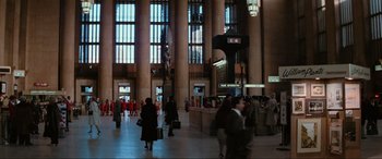 Movie still from “Blow Out” (1981), directed by Brian De Palma – People are walking in a large building with columns and windows; Extreme Wide shot, High angle