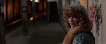 Movie still from “Blow Out” (1981), directed by Brian De Palma – A person with curly hair wearing a hat; Close Up shot, Over the shoulder angle