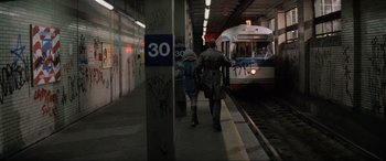 Movie still from “Blow Out” (1981), directed by Brian De Palma – Two people are walking towards a train at a train station; Wide shot, High angle