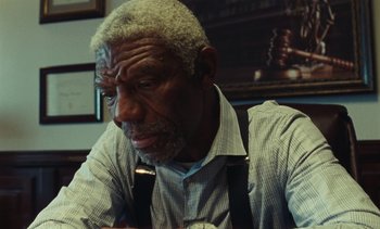 An older man sitting in front of a judge's gavel