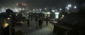 Movie still from “Blue Beetle” (2023), directed by Angel Manuel Soto – A group of people standing in the snow at night; Extreme Wide shot, High angle