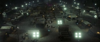 Movie still from “Blue Beetle” (2023), directed by Angel Manuel Soto – A group of people standing in the middle of a snowy field; Extreme Wide shot, High angle