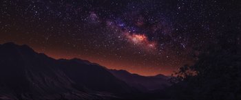 Movie still from “Blue Beetle” (2023), directed by Angel Manuel Soto – A night sky with stars and mountains in the background; Extreme Wide shot, Low angle