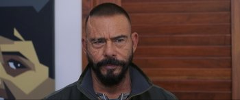 Movie still from “Blue Beetle” (2023), directed by Angel Manuel Soto – A person with a beard; Close Up shot, Over the shoulder angle