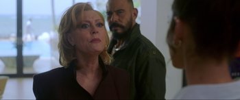 Movie still from “Blue Beetle” (2023), directed by Angel Manuel Soto – A woman standing next to a man in front of a mirror; Close Up shot, Over the shoulder angle