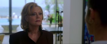 Movie still from “Blue Beetle” (2023), directed by Angel Manuel Soto – A person wearing a suit and tie; Close Up shot, Over the shoulder angle