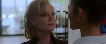 Movie still from “Blue Beetle” (2023), directed by Angel Manuel Soto – A woman is looking at another woman in a room; Close Up shot, Over the shoulder angle