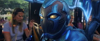 Movie still from “Blue Beetle” (2023), directed by Angel Manuel Soto – A blue and black mask with yellow glowing eyes; Close Up shot, Low angle