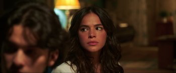 Movie still from “Blue Beetle” (2023), directed by Angel Manuel Soto – A woman with long brown hair stares into the distance; Close Up shot, Over the shoulder angle