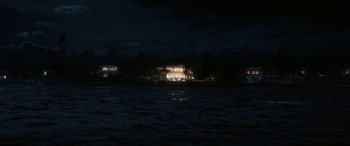 Movie still from “Blue Beetle” (2023), directed by Angel Manuel Soto – A house on the water at night time; Extreme Wide shot, High angle