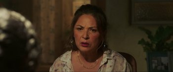 Movie still from “Blue Beetle” (2023), directed by Angel Manuel Soto – A person wearing a necklace; Close Up shot, Over the shoulder angle