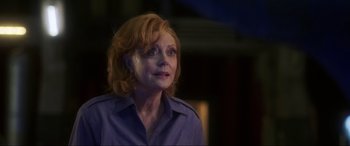 Movie still from “Blue Beetle” (2023), directed by Angel Manuel Soto – An older woman with red hair looking up at the sky; Close Up shot, Over the shoulder angle