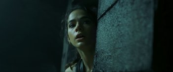 Movie still from “Blue Beetle” (2023), directed by Angel Manuel Soto – A beautiful young lady leaning against a wall; Close Up shot, Low angle