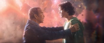 Movie still from “Blue Beetle” (2023), directed by Angel Manuel Soto – A man and a young boy are touching each other; Medium shot, Over the shoulder angle