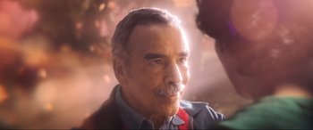 Movie still from “Blue Beetle” (2023), directed by Angel Manuel Soto – An older man with a mustache looking at the camera; Close Up shot, Over the shoulder angle