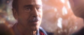 Movie still from “Blue Beetle” (2023), directed by Angel Manuel Soto – An older man with a mustache looking into the distance; Extreme Close Up shot, Over the shoulder angle