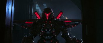 Movie still from “Blue Beetle” (2023), directed by Angel Manuel Soto – A red and black robot; Wide shot, Low angle