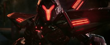 Movie still from “Blue Beetle” (2023), directed by Angel Manuel Soto – View of a red and black robot's face; Medium shot, Low angle