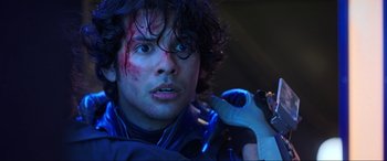 Movie still from “Blue Beetle” (2023), directed by Angel Manuel Soto – A person holding a cell phone; Close Up shot, Over the shoulder angle