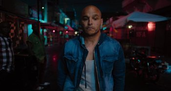 Movie still from “Blue Miracle” (2021), directed by Julio Quintana – A man in a blue jacket is standing in the street; Medium shot, Low angle