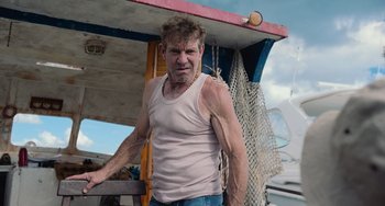 Movie still from “Blue Miracle” (2021), directed by Julio Quintana – A man standing on top of a boat in the water; Medium shot, Low angle