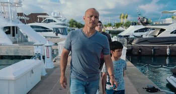 Movie still from “Blue Miracle” (2021), directed by Julio Quintana – A man and a boy walking down a sidewalk; Medium shot, Low angle