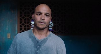 Movie still from “Blue Miracle” (2021), directed by Julio Quintana – A man with a bald head is standing in front of a wall; Close Up shot, Low angle