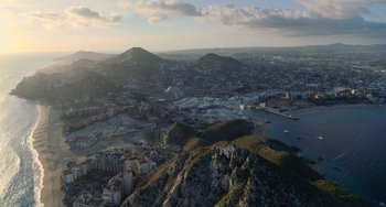 Movie still from “Blue Miracle” (2021), directed by Julio Quintana – An aerial view of a large city with mountains in the background; Extreme Wide shot, High angle