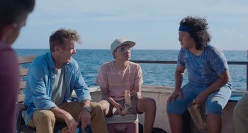 Movie still from “Blue Miracle” (2021), directed by Julio Quintana – A group of people sitting on top of a boat next to a body of water; Medium shot, Over the shoulder angle