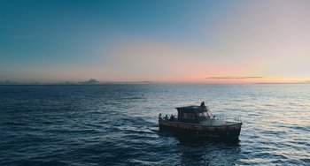 Movie still from “Blue Miracle” (2021), directed by Julio Quintana – A small boat in the middle of the ocean at sunset; Extreme Wide shot, Low angle