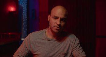 Movie still from “Blue Miracle” (2021), directed by Julio Quintana – A man with a bald head is posing for a picture; Close Up shot, Low angle