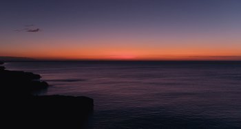 Movie still from “Blue Miracle” (2021), directed by Julio Quintana – A view of a body of water at sunset; Extreme Wide shot, Low angle