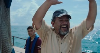 Movie still from “Blue Miracle” (2021), directed by Julio Quintana – A man in a hat and a man in a blue shirt; Medium shot, Low angle