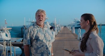 Movie still from “Blue Miracle” (2021), directed by Julio Quintana – An older man standing next to a woman on a pier; Medium shot, Low angle