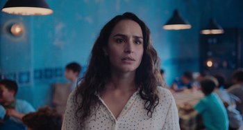 Movie still from “Blue Miracle” (2021), directed by Julio Quintana – A woman in a white polka dot shirt looking at the camera; Close Up shot, Over the shoulder angle