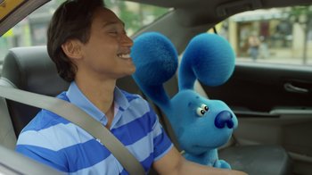 Movie still from “Blue's Big City Adventure” (2022), directed by Matt Stawski – A man sitting in a car holding a stuffed animal; Close Up shot, Over the shoulder angle