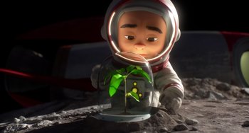 Movie still from “Blush” (2021), directed by Joe Mateo – An animated figure of an astronaut holding a plant in a jar; Medium shot, Overhead angle