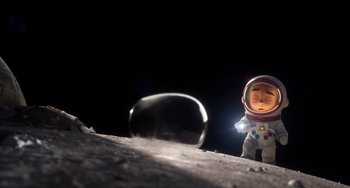 Movie still from “Blush” (2021), directed by Joe Mateo – An image of an action figure on the moon; Wide shot, Overhead angle