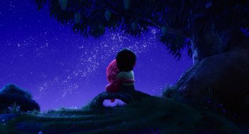 Movie still from “Blush” (2021), directed by Joe Mateo – A person sitting under a tree under a night sky; Extreme Wide shot, Low angle