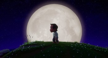 Movie still from “Blush” (2021), directed by Joe Mateo – A boy is standing in front of a large moon; Wide shot, Low angle