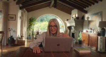 Movie still from “Book Club: The Next Chapter” (2023), directed by Bill Holderman – A woman sitting in front of an open laptop computer; Medium shot, Low angle