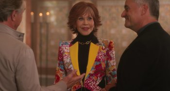 Movie still from “Book Club: The Next Chapter” (2023), directed by Bill Holderman – A woman wearing a colorful jacket talking to a man; Medium shot, Over the shoulder angle